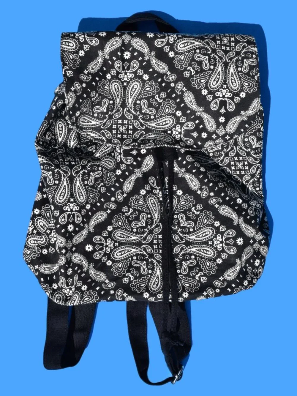 Mini canvas backpack featuring a bold black-and-white bandana/paisley print. Per